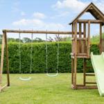 Holzspielplatz mit Schaukel und Rutsche im Garten