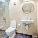 Badezimmer mit Dusche, Toilette und Waschbecken.