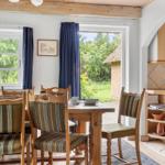 Esszimmer mit Holztisch, Stühlen und Blick auf Garten