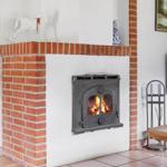 Kamin mit brennendem Holzofen, roter Ziegelsteinmauer und dekorativen Gegenständen.