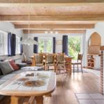 Wohn- und Essbereich mit Holzdecke, Kamin und Essgruppe.