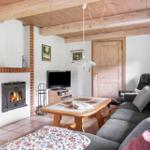 Wohnzimmer mit Kamin, Sofa, Tisch und Fernseher.