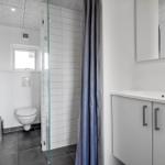 Badezimmer mit Dusche, Waschbecken und Toilette.