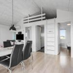 Wohnung mit Essbereich, Schlafbereich und Küche. Weiße Wände und Holzboden.