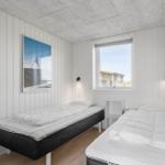 Zimmer mit zwei Betten, Fenster und Wandbild.