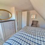 Schlafzimmer mit Bett, Kleiderschrank und Spiegel an der Wand.