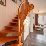 Holztreppenhaus mit Blick in Wohn- und Essbereich
