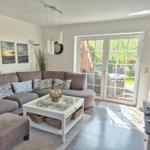 Wohnzimmer mit Sofa, Couchtisch und Glastür zum Garten.