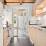 Küche mit Holzschränken, Kühlschrank, Herd und Spüle.