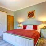 Schlafzimmer mit Bett, Nachttischen und Kleiderschrank.