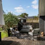 Terrasse mit Sitzgruppe, Sonnenschirm und Gartenansicht.