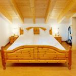 Schlafzimmer mit Holzbett, Nachttischen und Dachschrägen.