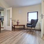 Living room with chair, table, and view into the kitchen.