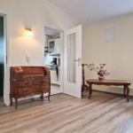 Entrance area with desk, table and chair. Kitchen and bedroom are visible.