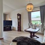 Living room with dining table, sofa, TV, and grandfather clock.