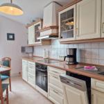 Kitchen with dining area, white cabinets, and wooden countertops.