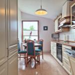 Kitchen with dining table, appliances, and window.