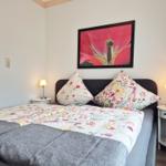 Bedroom with bed, two nightstands, and wall art.