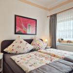 Bedroom with double bed, two nightstands, and window with curtains.