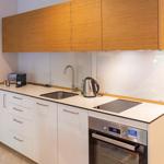 Küche mit Holzschränken, Edelstahlspüle und Kochfeld