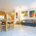 Wohn- und Essbereich mit Sofa, Tisch und Wandbildern