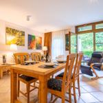 Esszimmer mit Holztisch, Stühlen und Blick auf Garten.