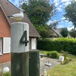 Haus mit Garten und Vogel auf Pfosten mit Hausnummer 4.