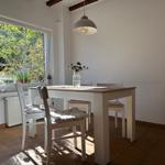 Esszimmer mit Tisch, Stühlen und Fensterblick auf Garten.