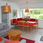 Wohn- und Essbereich mit Holztisch, Sofa und Blick auf den Garten.