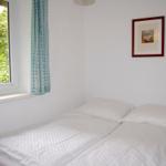 Schlafzimmer mit Doppelbett, Fenster und Bild an der Wand.