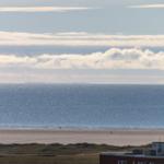 Weitläufiger Strand mit Blick auf das Meer und Wolken