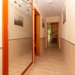 Flur mit Holztüren, Fliesen und Bildern an den Wänden.