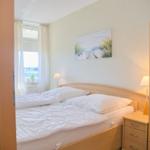 Schlafzimmer mit Bett, Nachttisch und Wandbild