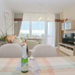 Wohnzimmer mit Essbereich, TV und Blick aufs Meer.