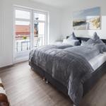 Schlafzimmer mit Doppelbett, Balkon und Wandbild.