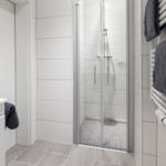 Badezimmer mit Duschkabine, Handtuchhalter und Fliesenboden.