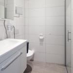 Badezimmer mit Dusche, Waschbecken und Toilette.