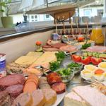 Breakfast table with sausage, cheese, eggs, and vegetables