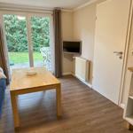 Wohnzimmer mit Couch, TV und Zugang zur eigenen Terrasse