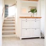 Eingangsbereich mit Schrank, Spiegel und Treppe.