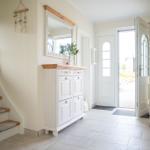 Eingangsbereich mit Garderobe, Spiegel und Treppe zur oberen Etage.