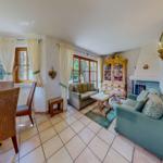 Wohn- und Essbereich mit Sofa, Tisch und Fenstern.