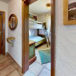 Durchgang in ein Schlafzimmer mit Doppelstockbett und Holzrahmen.