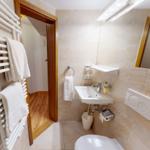 Badezimmer mit Dusche, Waschbecken und Heizkörper.