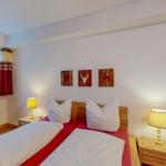 Schlafzimmer mit Doppelbett, zwei Nachttischen und Wanddekoration.