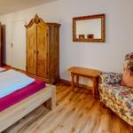 Schlafzimmer mit Bett, Schrank, Sofa und Spiegel an der Wand.