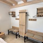 Schlafzimmer mit Kleiderschrank, Bänken und Hakenwand.