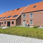 Rotes Ziegeldach mit Dachfenstern und Terrasse mit Garten.