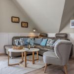 Wohnzimmer mit Sofa, Stuhl und Tisch unter schrägen Decken