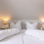 Schlafzimmer mit Doppelbett, zwei Nachttischen und Lampen.